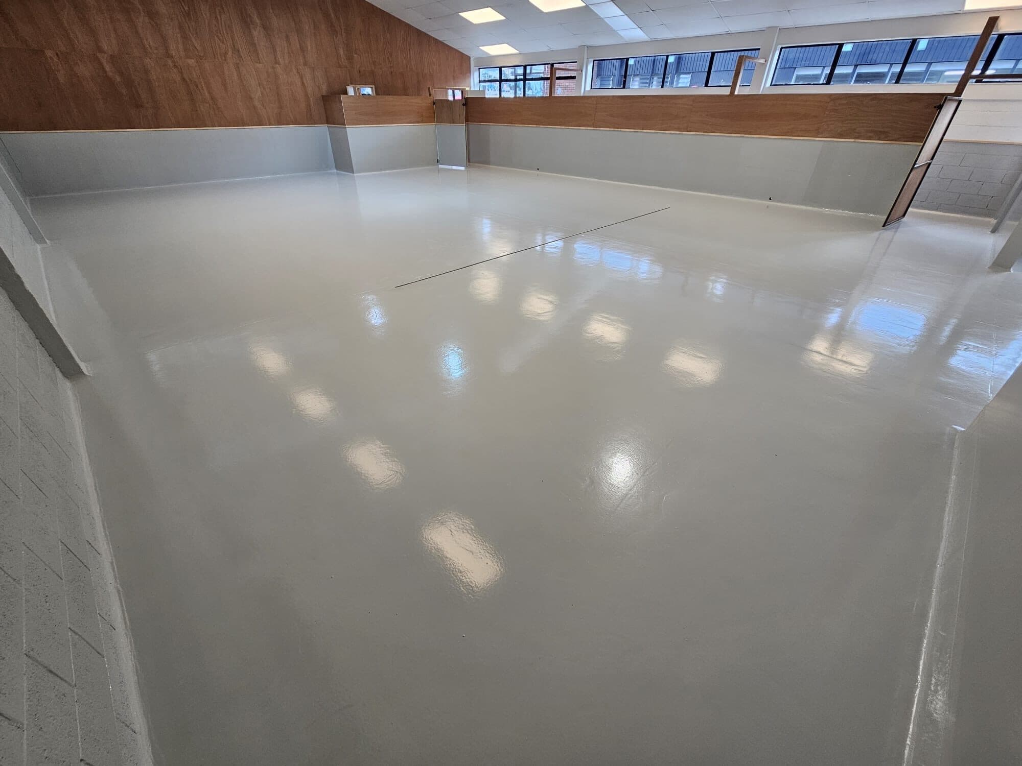A durable, easy-to-clean light-grey epoxy floor built for a high-traffic commercial facility.